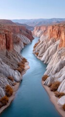 Dramatic Aerial View Of A Winding Blue River Through Rugged Canyon Cliffs With Sparse Autumn Foliage Under A Clear Sky