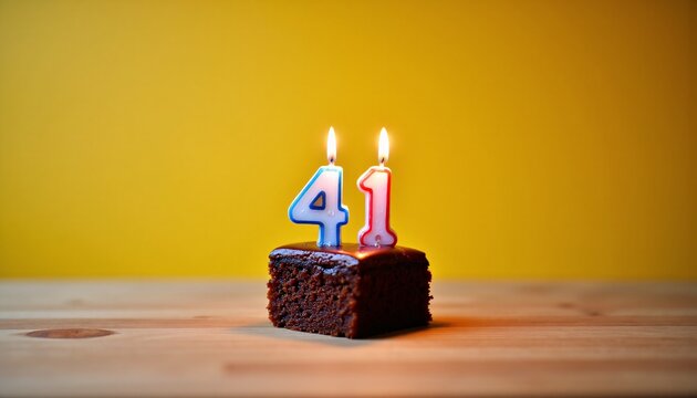 Chocolate cake slice with 41st birthday candles.