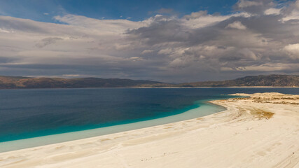 The combination of Lake Salda's pure white shallows and deep blue waters with the dramatic cloudy mountain landscape. Unique nature.