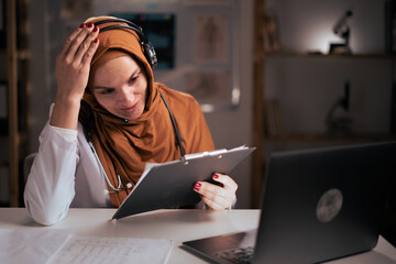 Telehealth concept. Tired sad Muslim woman doctor in headset thinking problem feeling stress on...