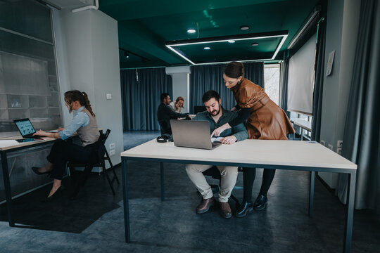 Colleagues working together in a modern office setting, engaging in teamwork and discussions.