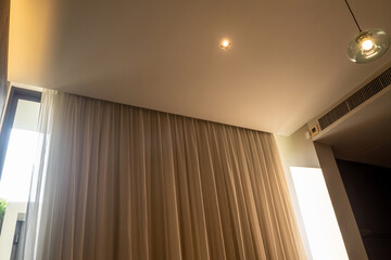 Bright light from outside poured into the room through the side of the curtains