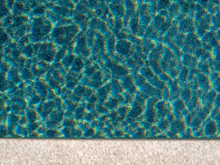 Ripples reflecting sunlight from the clear water in the swimming pool