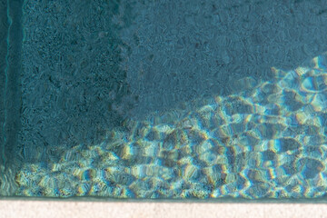 Ripples reflecting sunlight from the clear water in the swimming pool