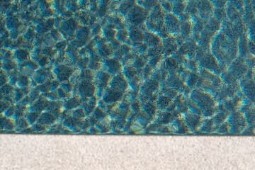 Ripples reflecting sunlight from the clear water in the swimming pool