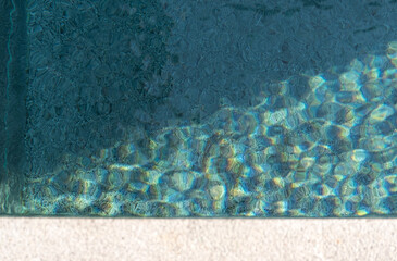 Ripples reflecting sunlight from the clear water in the swimming pool