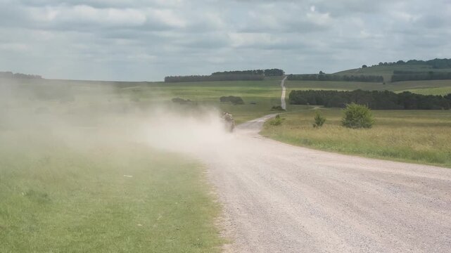 soldiers in a high speed light mobility vehicle on a dusty track