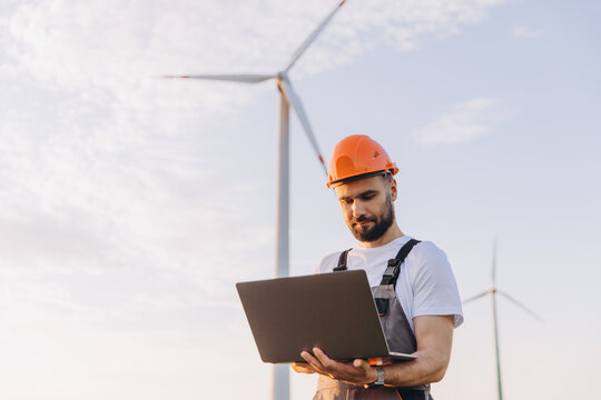 Technician working with laptop in a wind turbine power plant