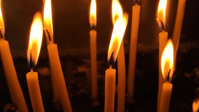 Religious candles inside an Orthodox monastery, warm glow, soft wax and gentle light in a quiet chapel