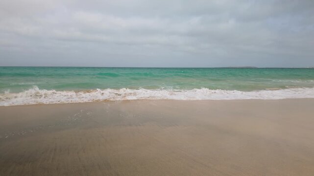 Atlantic Ocean waves breaking on an empty sand beach on the Cape Verde island of Boa Vista.