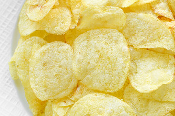 Potato chips or crisps texture background. Crunchy fried potato slices.