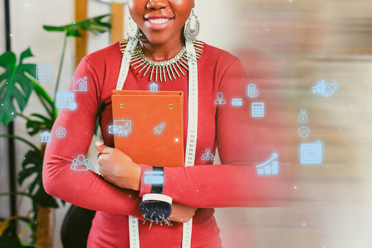 Professional woman holding a notebook and measuring tape with digital icons representing business concepts - Powered by Adobe