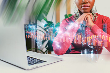 Woman using laptop with data visualization in an office setting during the daytime