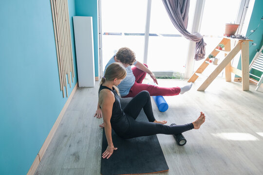 man and woman training using mfr or massage roll at home - Powered by Adobe
