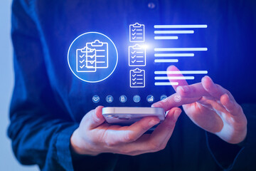 Person using a smartphone to manage tasks with digital checklists and data visualization in modern workspace