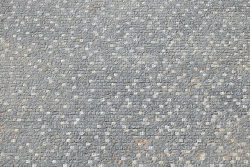 Fototapeta premium Textured gray cobblestone pavement with varying shades and patterns, showcasing the intricate design and craftsmanship of stonework in an outdoor setting