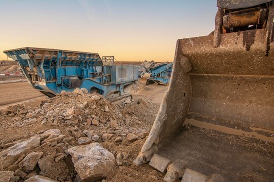 Heavy and mobile machinery in a quarry to transform stone into construction material
