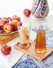 Apple Iced Tea with Fresh Apples and Cinnamon on Blue Pattern Table