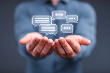Businessman engaged in modern communication holding chat bubbles in hands