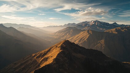 Glowing sunlit mountain ridge stretching through high-altitude alpine region, with misty valleys