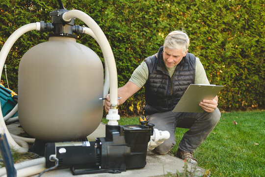 Electrician working on heat pump close to a pool