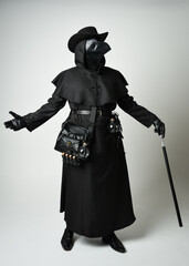 Obraz premium Plague Doctor Full length walking Silhouette Portrait of Gothic Halloween Character with Beak Mask, Black Cloak on White Studio Background, Dramatic Dark Costume and Fantasy Horror figure