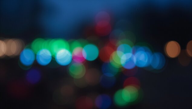 Displaying abstract cluster of multicolored blurred lights in urban night scene, with bokeh effect