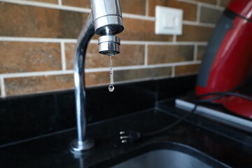Close up of drop of water m the metal faucet of face wash bath in the bathroom 