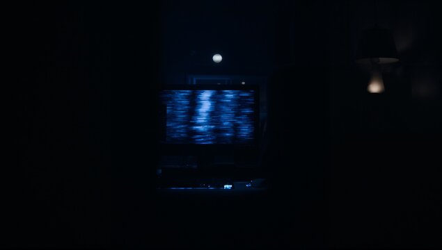 Flickering screen showing blue static in dark living room, with console and lampshade lamp