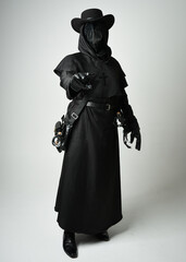 Fototapeta premium Plague Doctor Full length walking Silhouette Portrait of Gothic Halloween Character with Beak Mask, Black Cloak on White Studio Background, Dramatic Dark Costume and Fantasy Horror figure