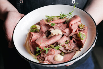 Gourmet roast beef carpaccio with capers and fresh greens