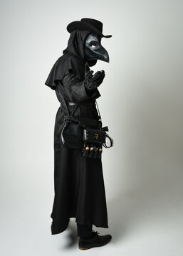 Plague Doctor Full length walking Silhouette Portrait of Gothic Halloween Character with Beak Mask, Black Cloak on White Studio Background, Dramatic Dark Costume and Fantasy Horror figure
