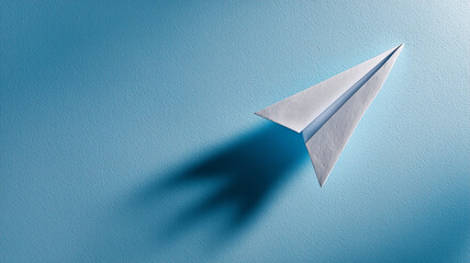 青背景に浮かぶ紙飛行機のミニマル写真の場面