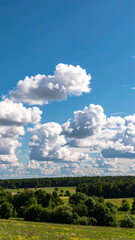 Scenic landscape of blue sky and white clouds over rolling green hills