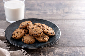 Chocolate chip cookies and milk for breakfast on rustic wooden table. Copy space