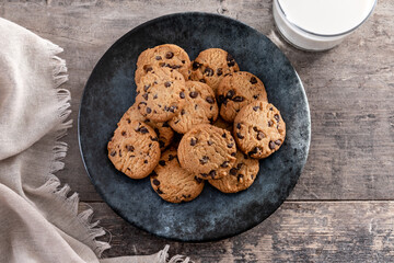 Chocolate chip cookies and milk for breakfast on rustic wooden table. Top view