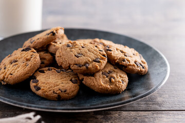 Chocolate chip cookies and milk for breakfast on rustic wooden table