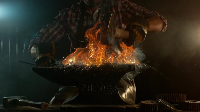 Close-up of blacksmith forging glowing hot iron on anvil with flying sparks. Super slow motion filmed on high-speed cinema camera at 1000 fps