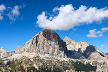 Mountain landscape in the alps with an white cloud touching an peak