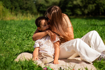 Fototapeta premium Joyful moment of happy mother spending time with her kid. Laughing, kissing, hugging, tickling. Parenthood moment.