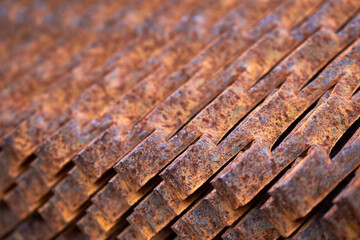 Perforated rusty metal floor sheet stamping plates texture closeup angled view. Metal stamping sheet metal manufacturing lightweight bearing flooring elements structural combine strength functionality