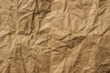 Brown crumpled kraft paper texture with deep folds and creases