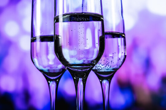 An upscale gathering characterized by illuminated drinkware and energetic social interactions