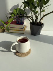 Cozy Workspace with Cup of Tea and Indoor Plant – Minimal Home Office with Green Plant and Warm Light