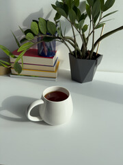 Cozy Workspace with Cup of Tea and Indoor Plant – Minimal Home Office with Green Plant and Warm Light