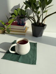 Cozy Workspace with Cup of Tea and Indoor Plant – Minimal Home Office with Green Plant and Warm Light