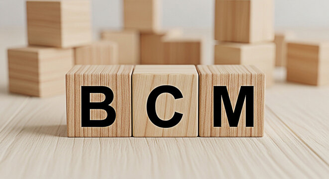 Wooden blocks spelling bcm on a light wooden surface representing business continuity management and related concepts in a minimalist style