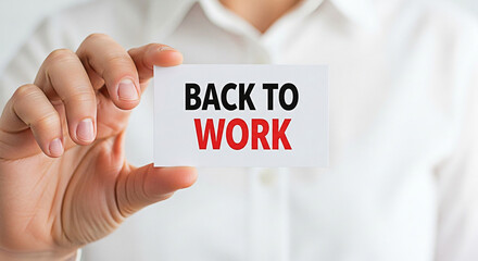 Hand holding a card that says back to work in black and red text promoting return to the office and employment opportunities now available