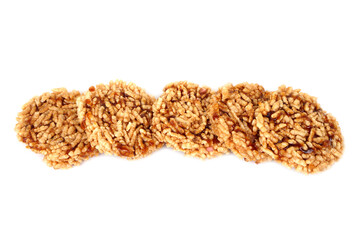 Row of traditional Thai crispy rice crackers with sweet caramel syrup on white background. Crunchy puffed rice snack showing authentic Thai dessert style and local homemade delicacy.