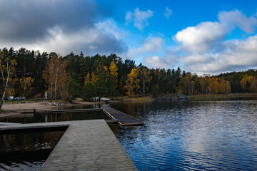 A wooden pier jetty marina for boats yachts on Baltic Sea bay. A tranquil autumn landscape of Scandinavia.